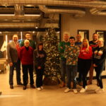 the full abbey team at christmas are lined up in front of a christmas tree