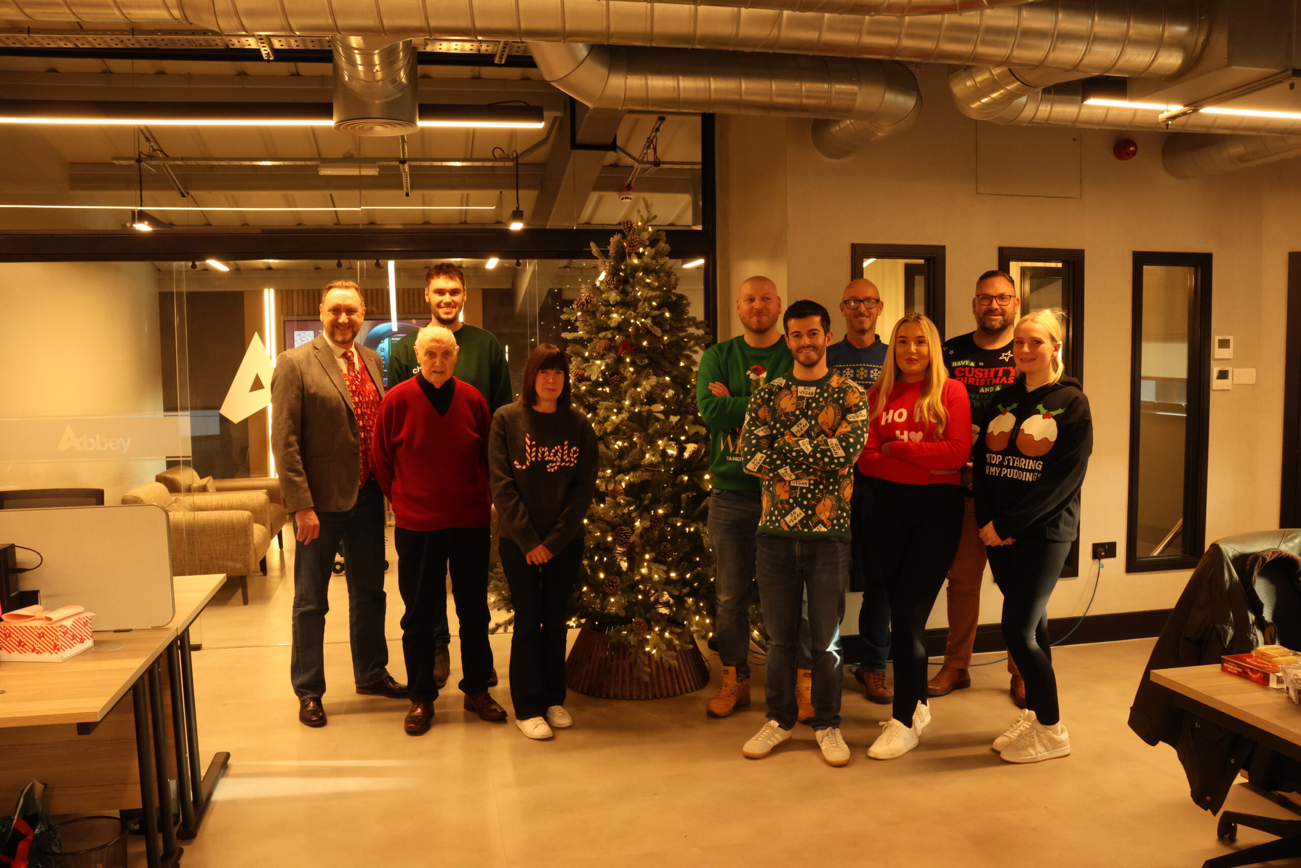 the full abbey team at christmas are lined up in front of a christmas tree