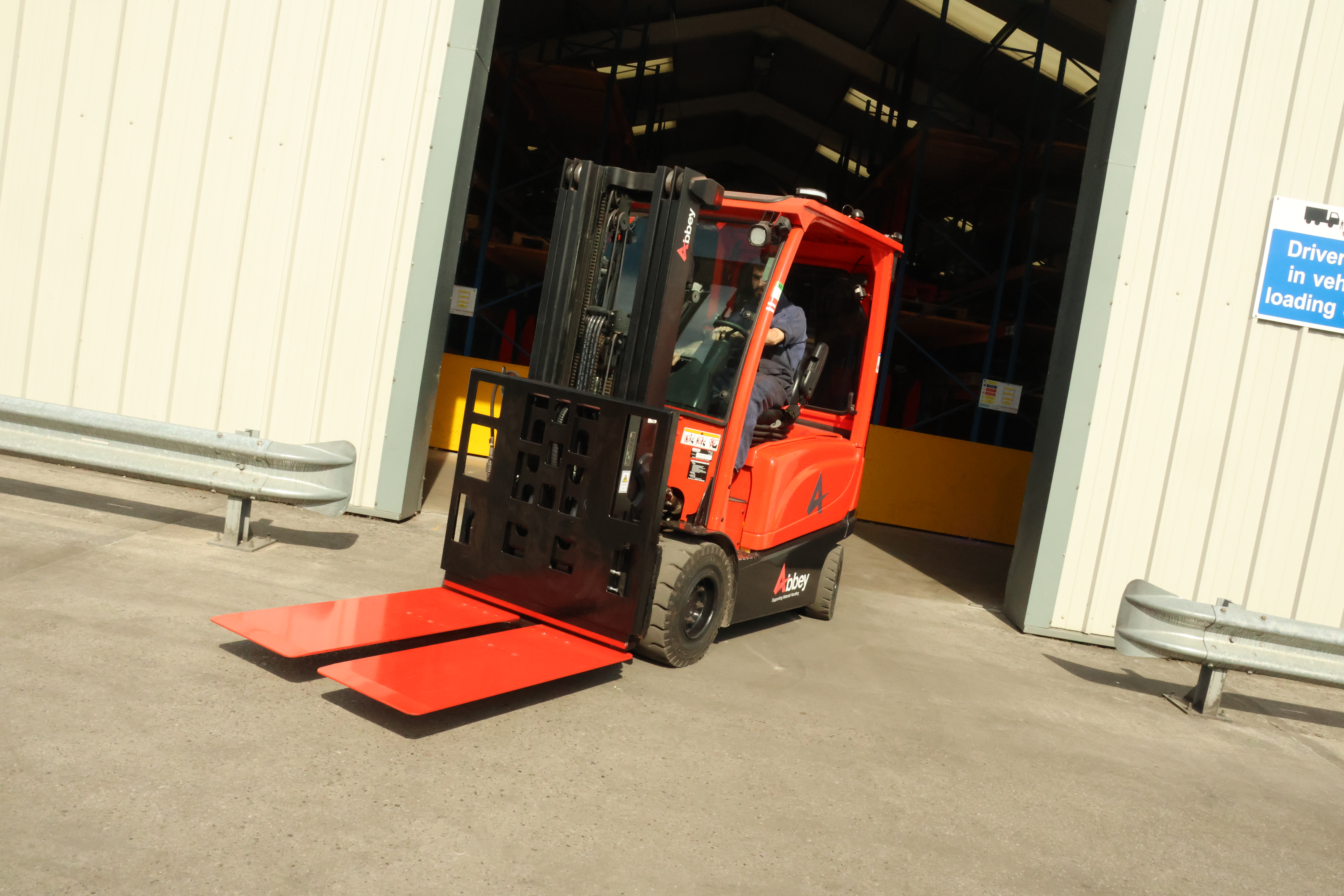 a red and black longhe push pull is on a red abbey forklift truck outside a warehouse
