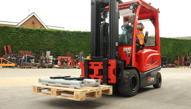 iCP forklift mobile weighing system is installed on the red abbey forklift truck while holding a wooden pallet