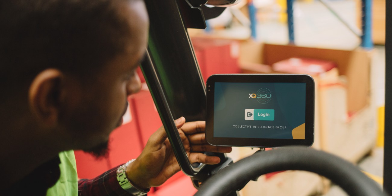 we see an operator interact with a touchscreen monitor with the xq360 forklift telematics system login screen being presented