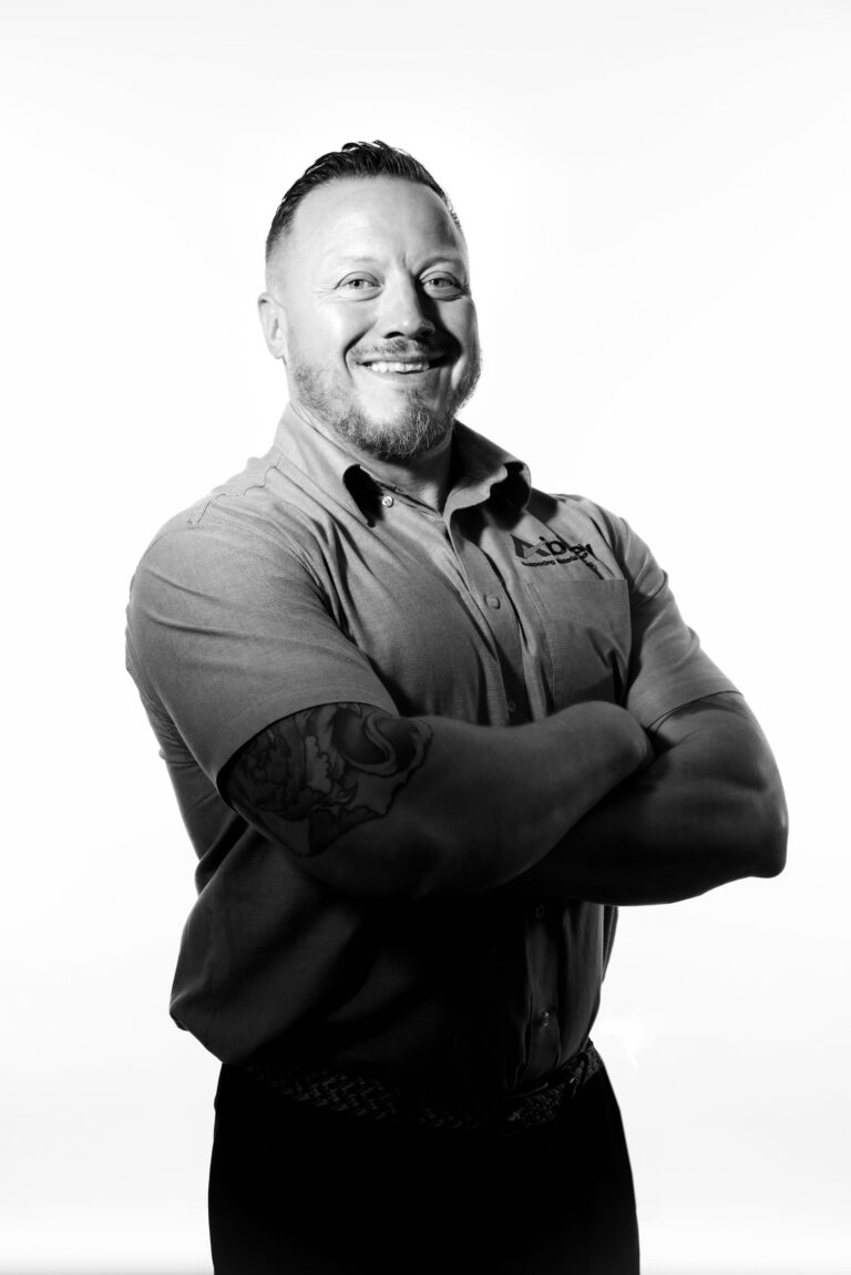 andy entwistle is wearing a grey abbey-branded shirt with his arms folded and smiling at the camera.