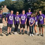abbey staff members are wearing purple coloured memory walk 2025 t shirts with gold medals round their necks