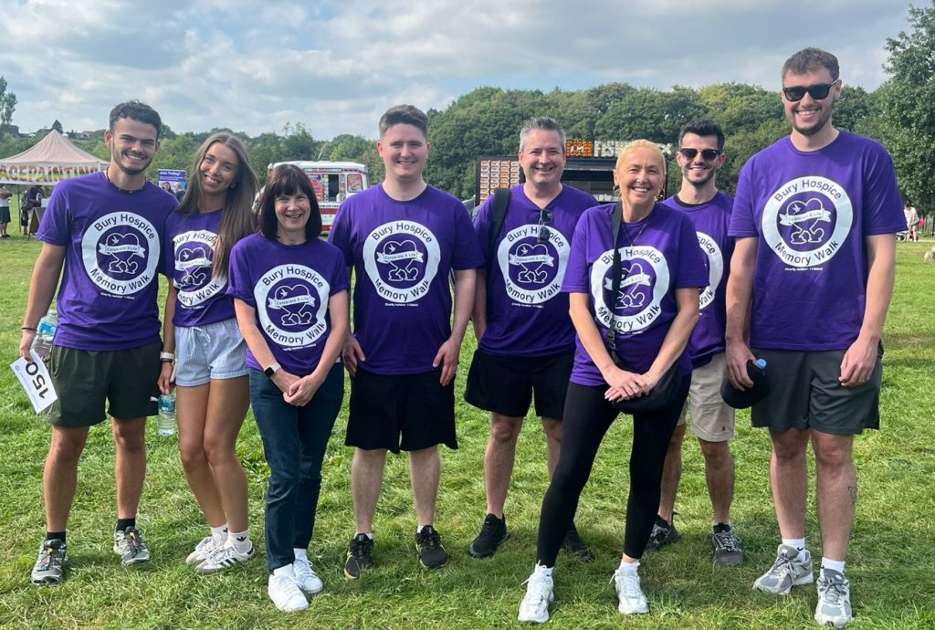 the abbey staff members are smiling at the camera wearing purple coloured memory walk 2025 t shirts 