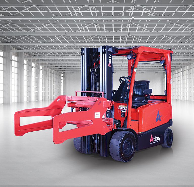 an abbey forktruck with a bale clamp is in the middle of an empty, white warehouse