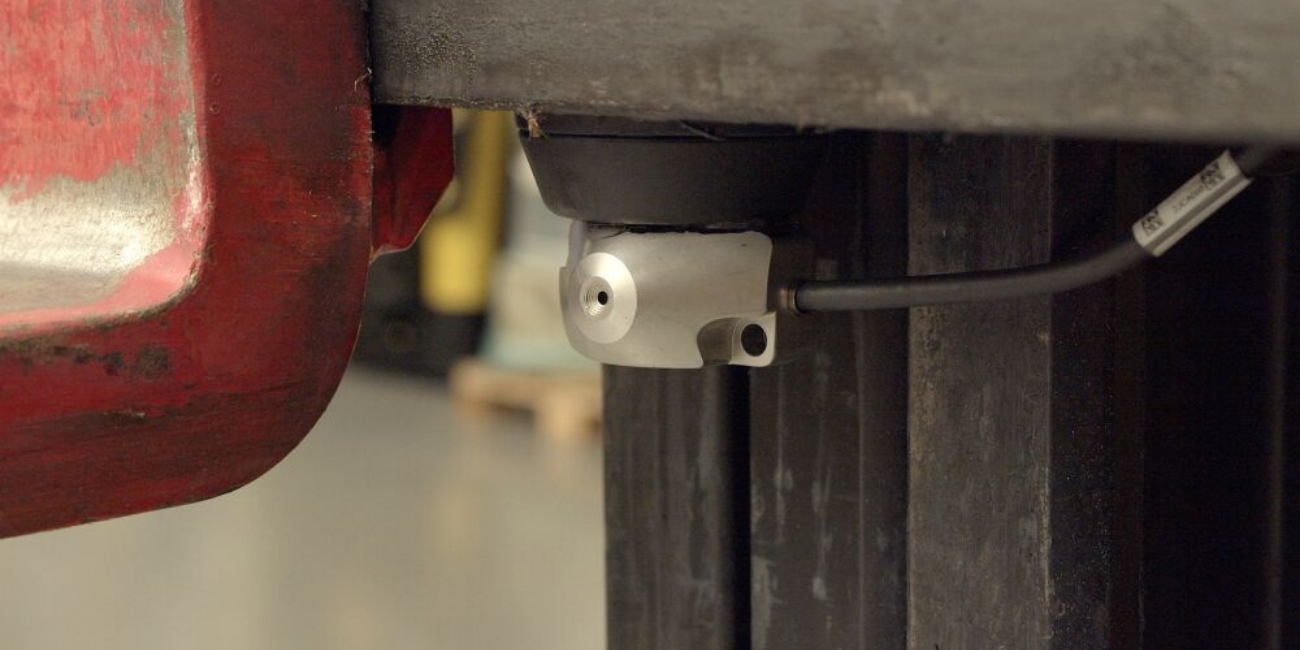 the silver orlaco cph forklift safety camera is attached to a forktruck behind the fork