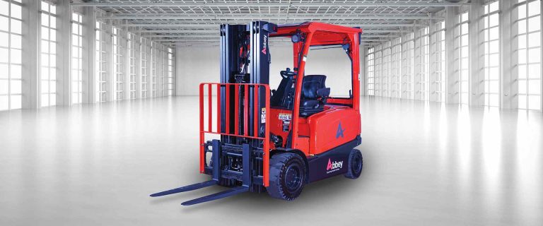 an abbey forktruck in the middle of an empty, white warehouse