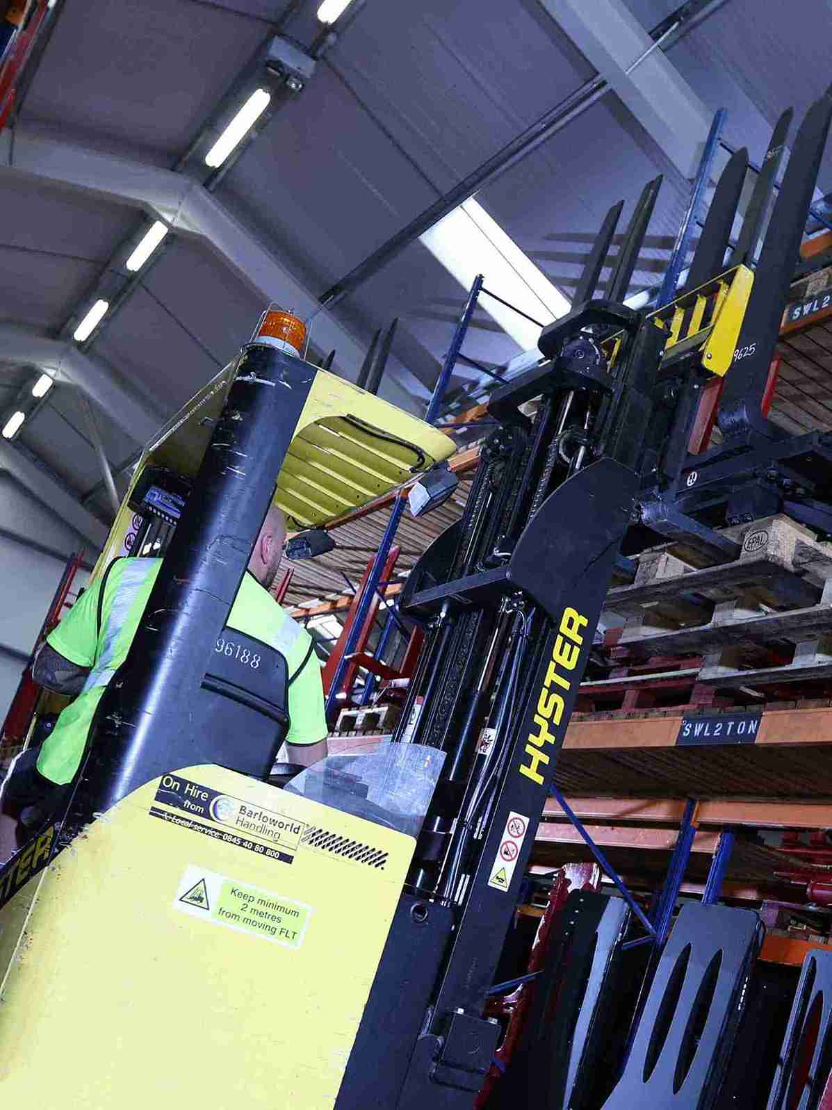 Yellow hyster yal forklift truck is retrieving a pallet in double deep storage from high racking