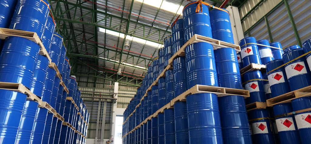 blue metal cylinders a stacked up on wooden pallets inside a large warehouse