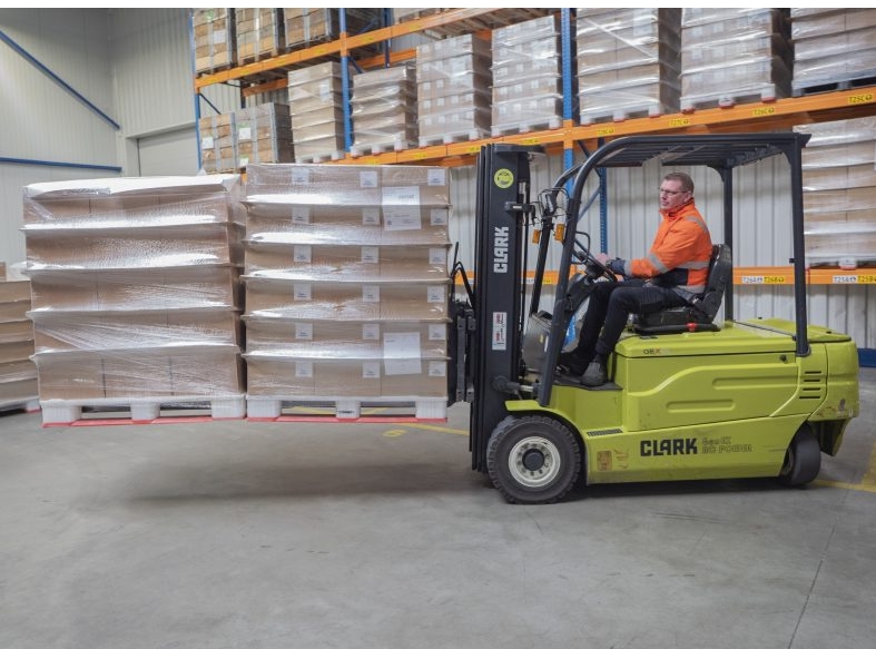 the kooi® reachforks are attached to a yellow forklift truck and are holding two pallets at the same time