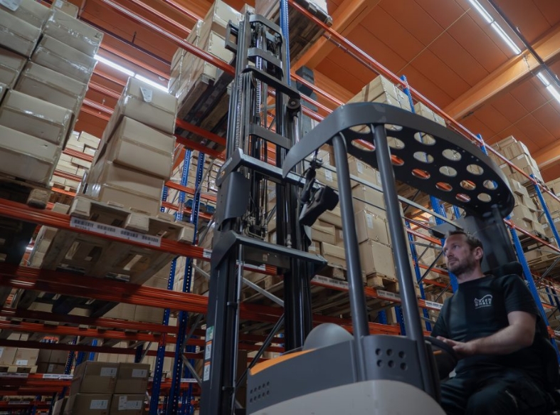 a pair of kooi®reachforks are attached to reach truck while it is reaching for a pallet on some high racking