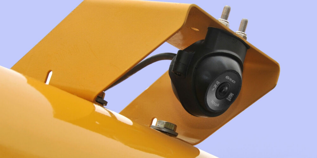 the black oralco amos forklift safety camera is attached to the top of a yellow forklift truck