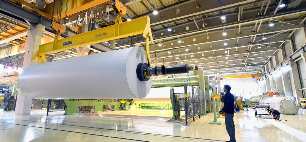 we can see a large white paper role inside a huge warehouse