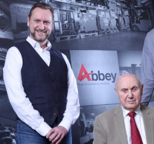 paul saunders is standing on the left wearing a waistcoat and white shirt next to his father vincent, who is sitting down wearing a beige blazer
