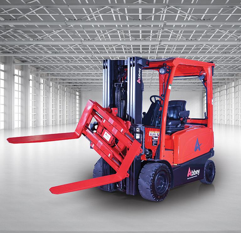 an abbey forktruck with red rotating fork clamp is in the middle of an empty, white warehouse