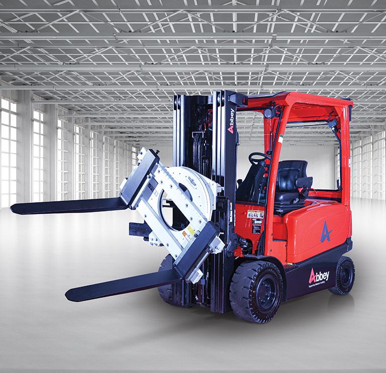 an abbey forktruck with a rotator clamp is in the middle of an empty, white warehouse
